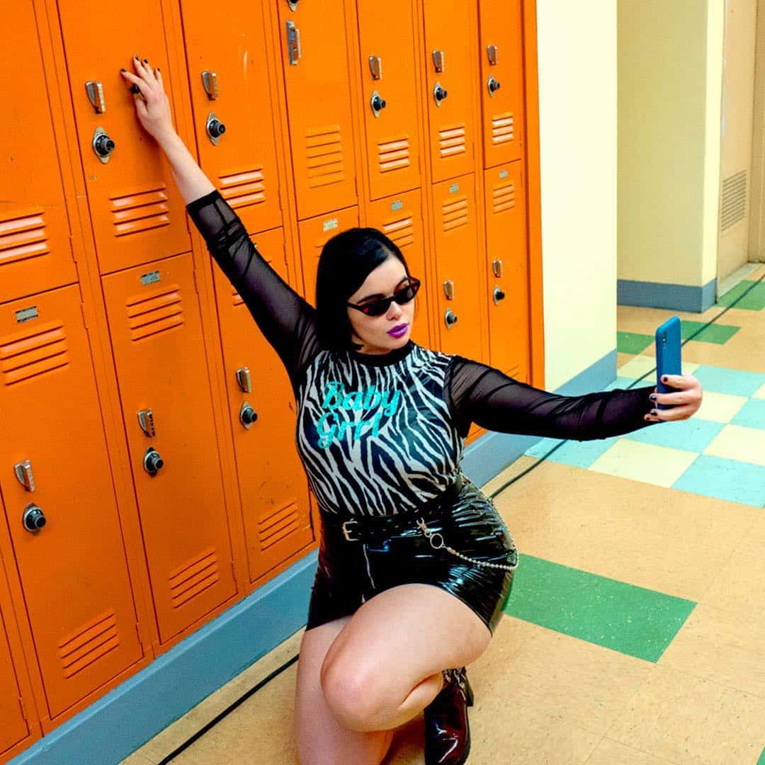 Kat Hernandez squatting by lockers