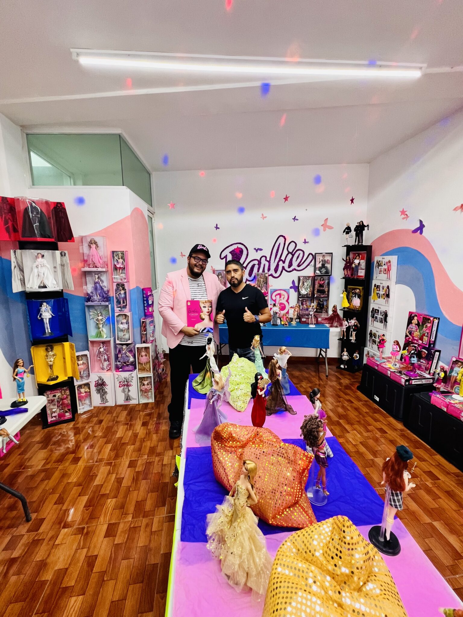 Dr. Paul Sebastian Juarez Velasquez and a friend with his prized Barbie collection in his "Barbieteca."