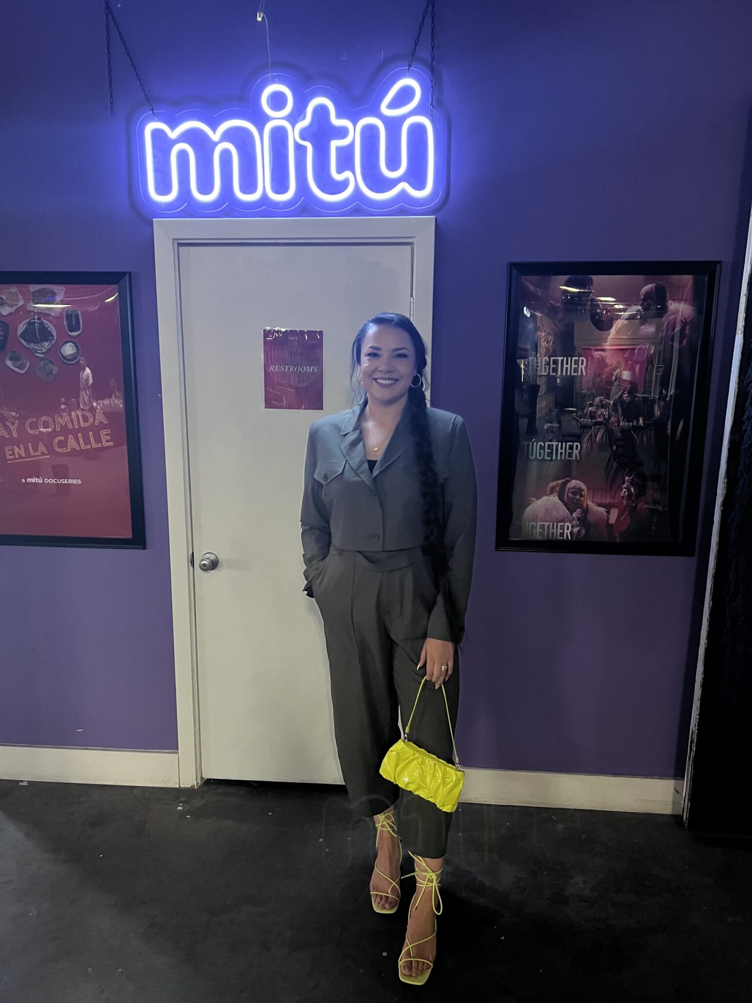 Taylor M. Tieman posing underneath the mitú neon sign.