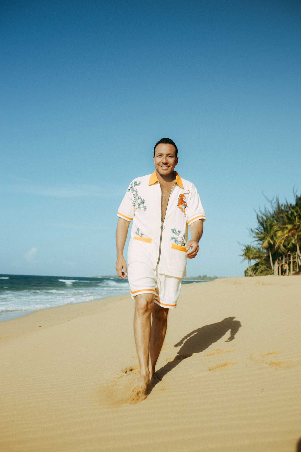 Promo shot of Howie D walking on the beach